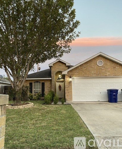 A house with a tree in front and a white garage door.