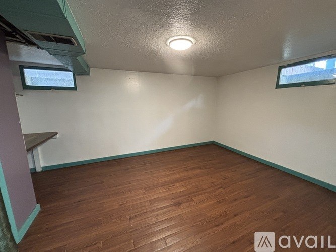 A room with wooden flooring and a window on the wall.