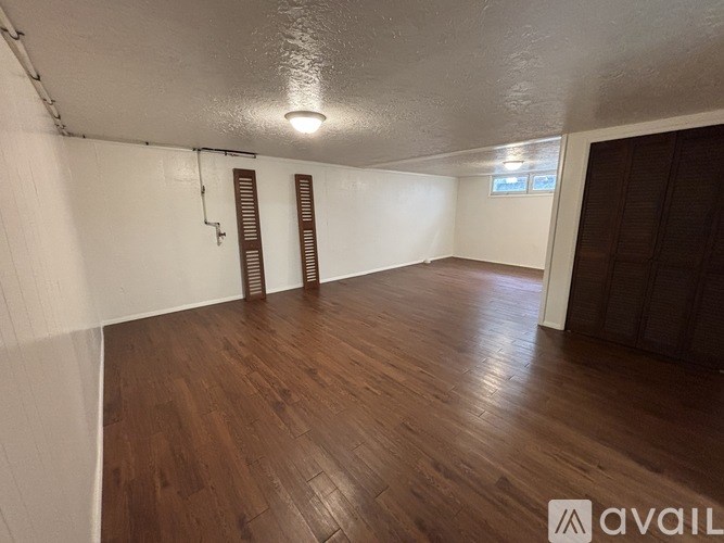 A room with wooden flooring and white walls.