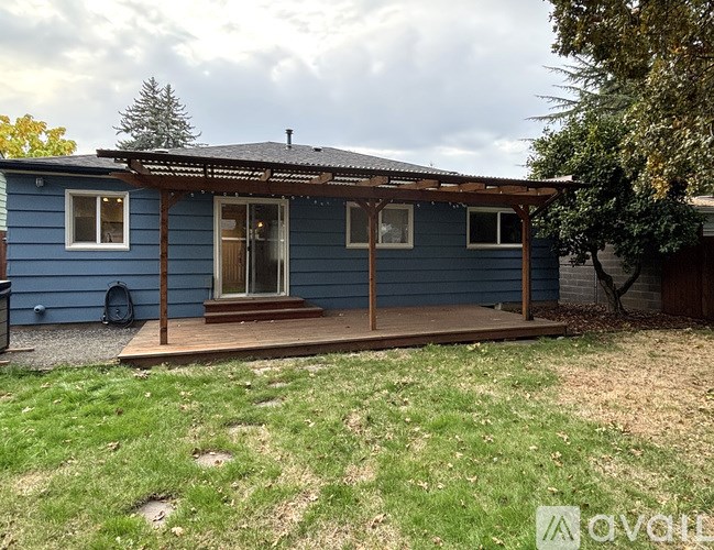 A blue house with a covered porch and a backyard.