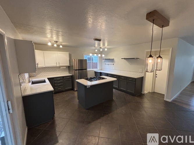 A kitchen with black cabinets and a white countertop.