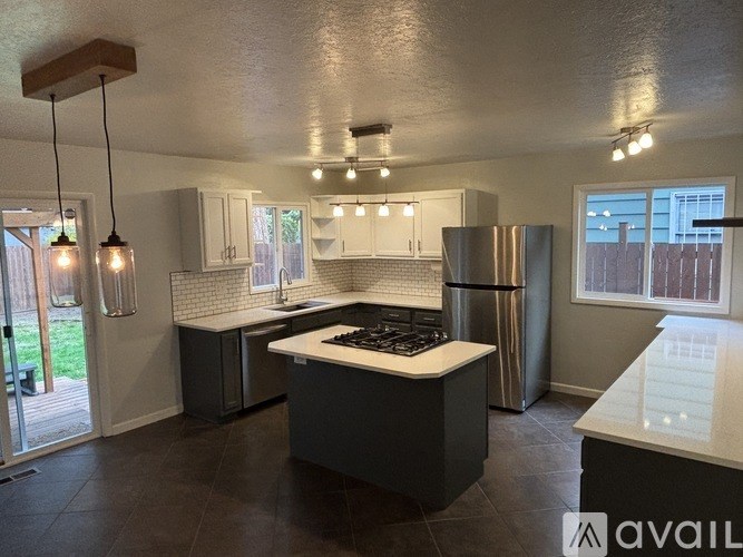 A kitchen with a black countertop and a white fridge.
