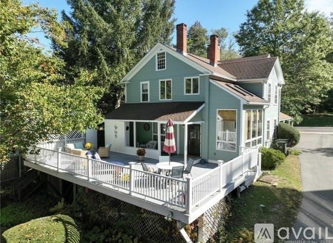 A house with a porch and a balcony overlooking a road.