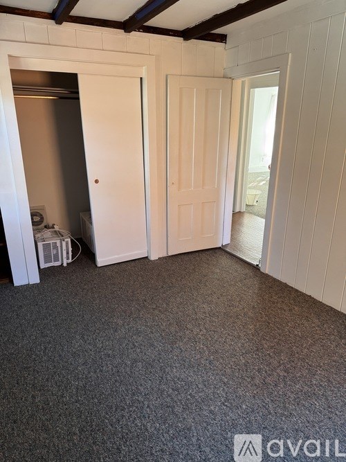 A room with a carpeted floor and white walls.