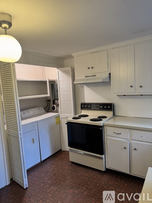 A kitchen with white cabinets and a black stove top oven.