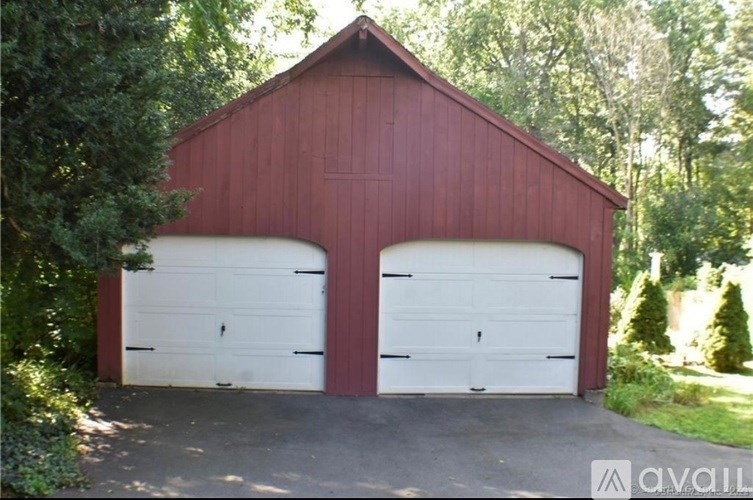A red barn with two white garage doors.