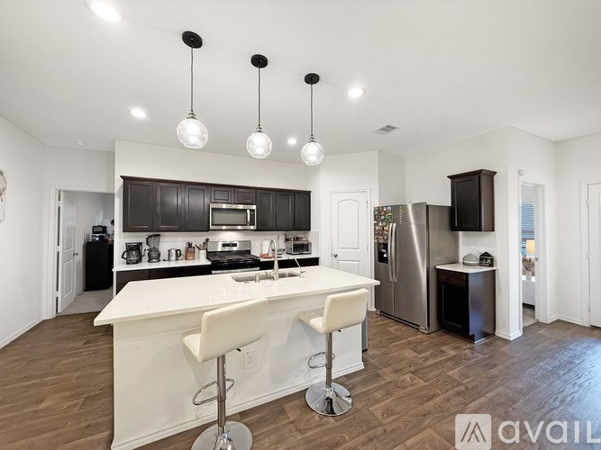 A modern kitchen with a white island and stainless steel appliances.