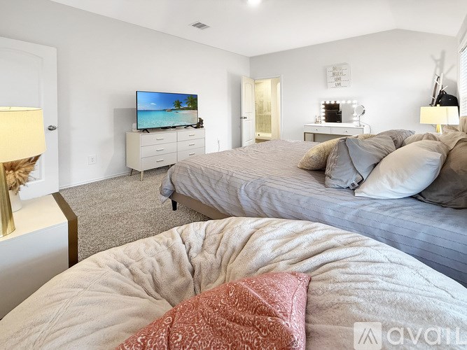 A bedroom with a large bed and a flat screen TV.