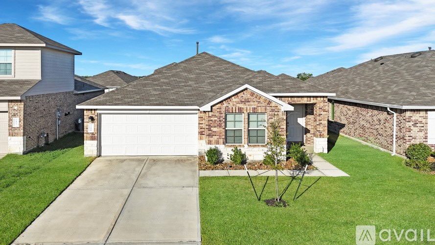 A house with a driveway and a tree in front of it.