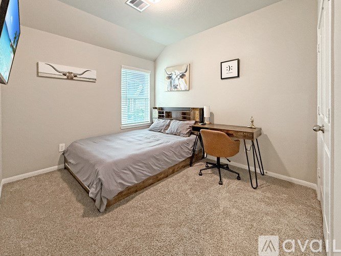 A bedroom with a bed, desk, and chair.