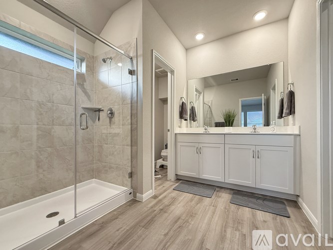 A bathroom with a walk-in shower and double sinks.