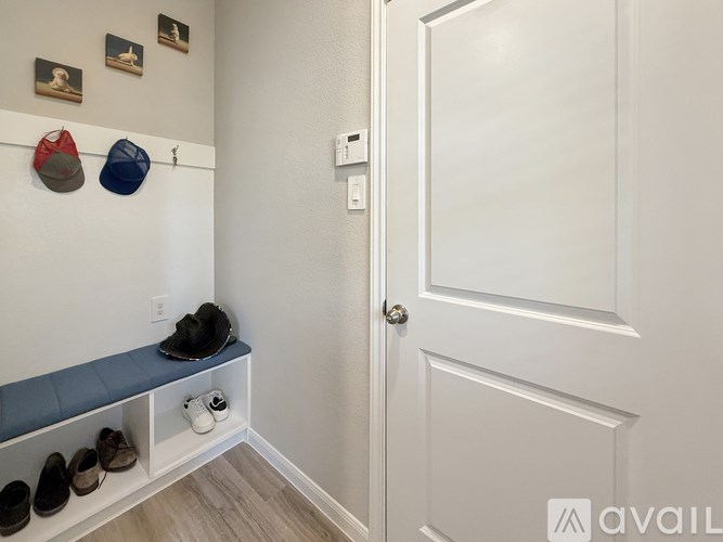 A hallway with a bench and shoes on it.