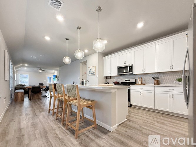 A kitchen with white cabinets and a wooden island.