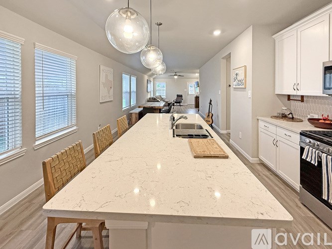 A kitchen with a marble table and wooden chairs.