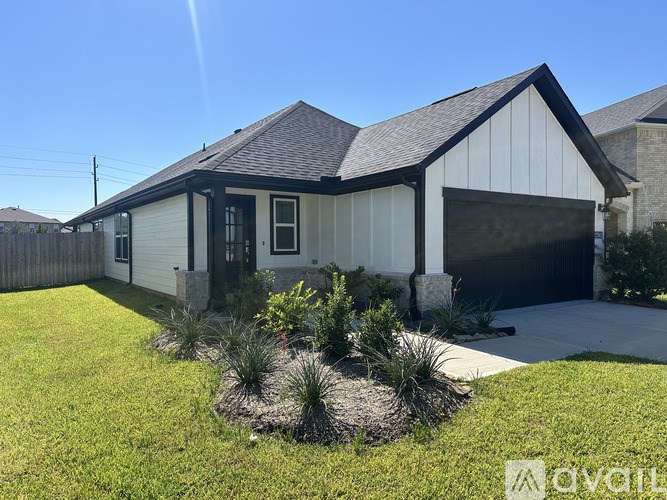 A white house with a black roof and a garage door.