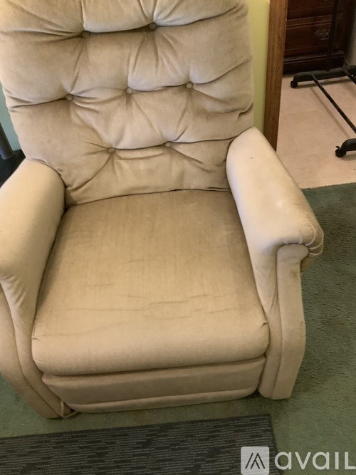 A beige recliner chair with a cushioned seat and backrest.