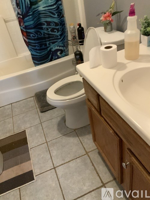 A white toilet sits in a bathroom next to a sink.