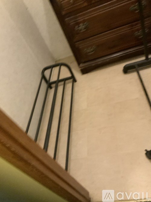 A black metal rack is on a white wall.