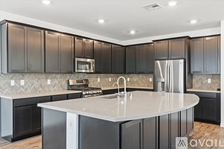 A kitchen with a white island and dark brown cabinets.