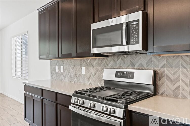 A kitchen with a stove and a microwave above it.