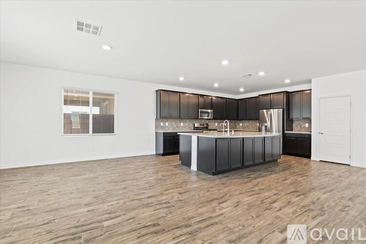 A spacious kitchen with wooden flooring and modern appliances.