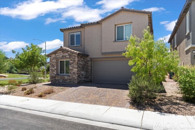 A house with a grey garage door and a brown brick wall.