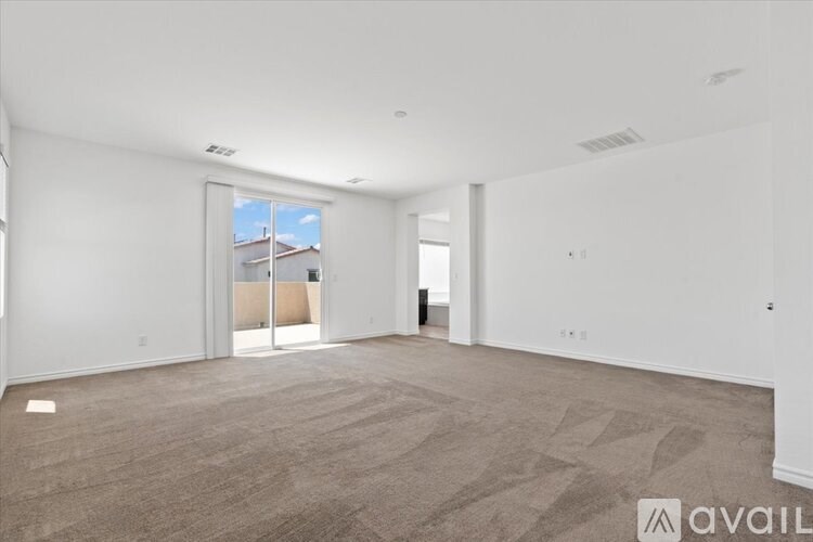 A spacious, empty room with a carpeted floor and a window.