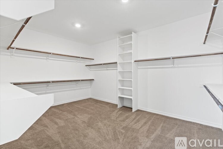 A room with a carpeted floor and a white wall with a ladder in it.