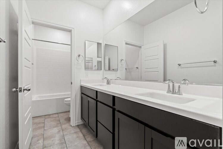 A bathroom with a white sink and a white door.