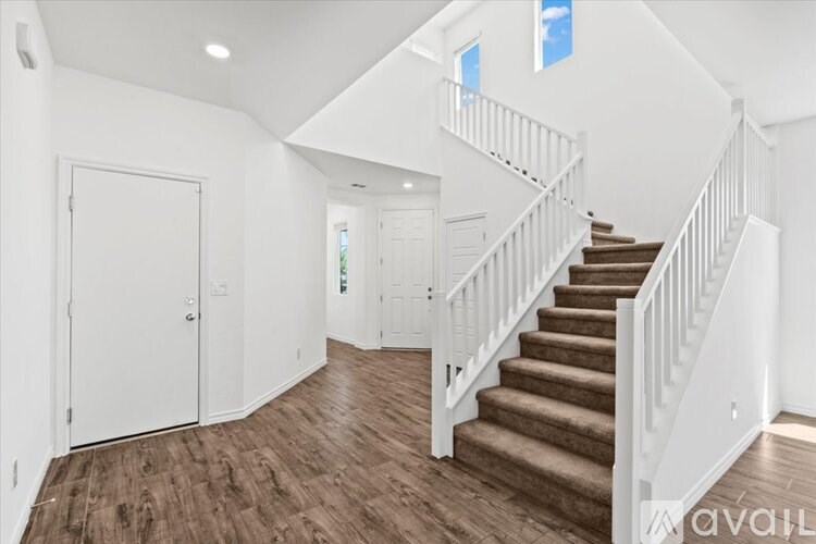 A spacious room with a staircase leading to the second floor.