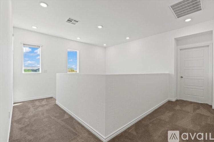 A room with a carpeted floor and a door on the right side.