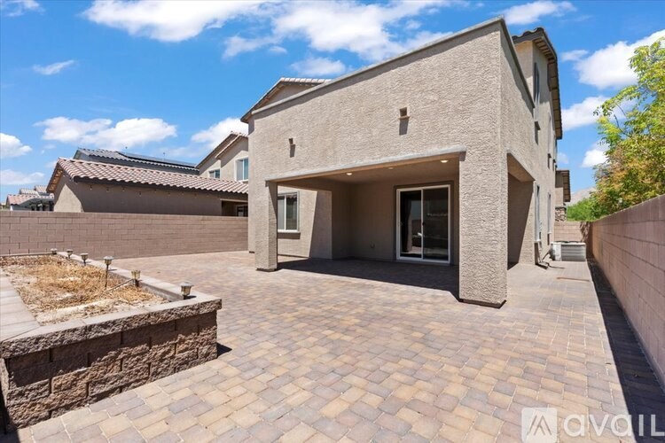 A modern house with a stone wall and a driveway.