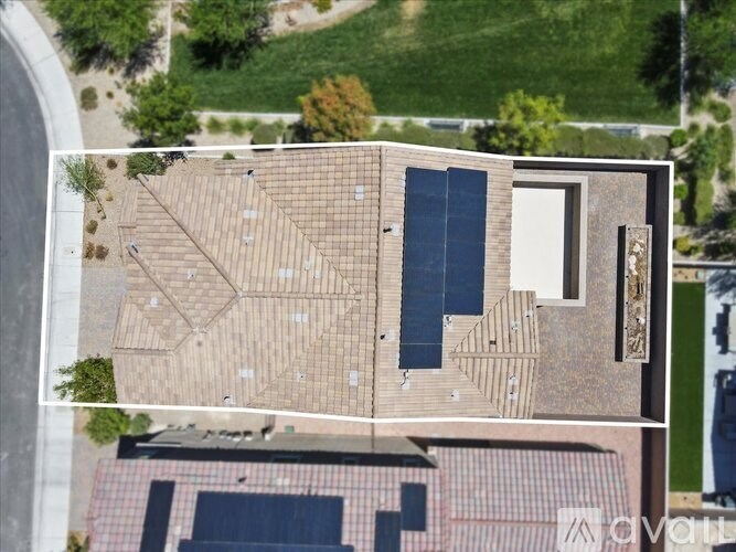 A modern building with a flat roof and large windows is surrounded by a grassy area.