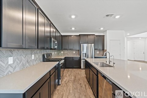 A modern kitchen with dark wood cabinets and a white countertop.