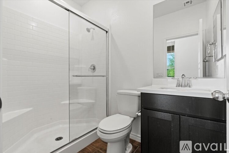 A white toilet sits in a bathroom with a black cabinet.