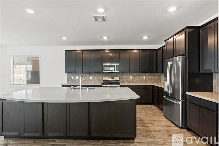 A modern kitchen with dark wood cabinets and a central island.