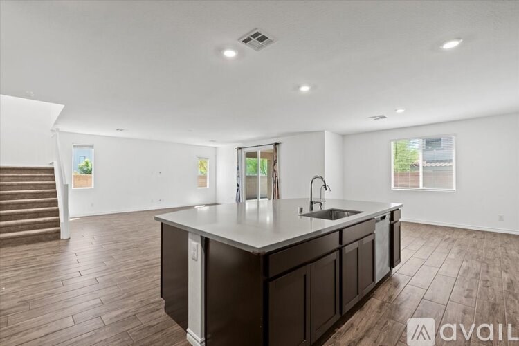 A kitchen with dark wood cabinets and a white countertop is available for rent.