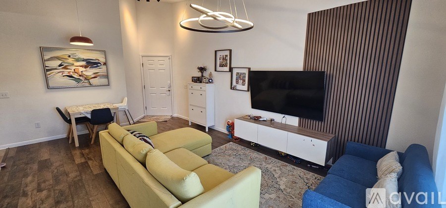 A living room with a yellow couch and a television.