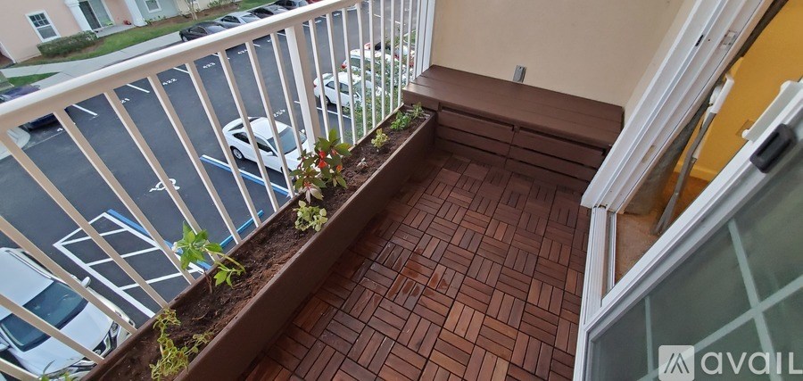 A balcony with a white railing and a planter box with flowers.