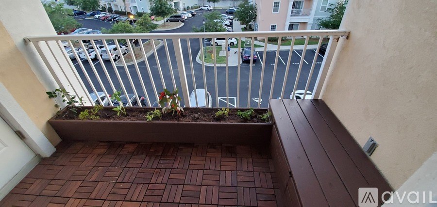 A balcony with a planter box and a view of a parking lot.