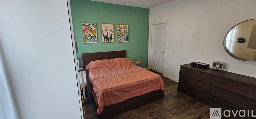 A bedroom with a bed, dresser and mirror.
