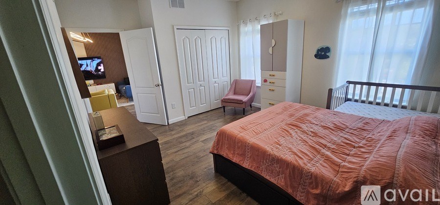 A bedroom with a bed, a chair, and a television.