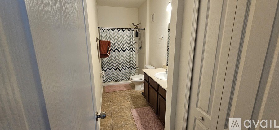 A bathroom with a toilet, sink, and shower.