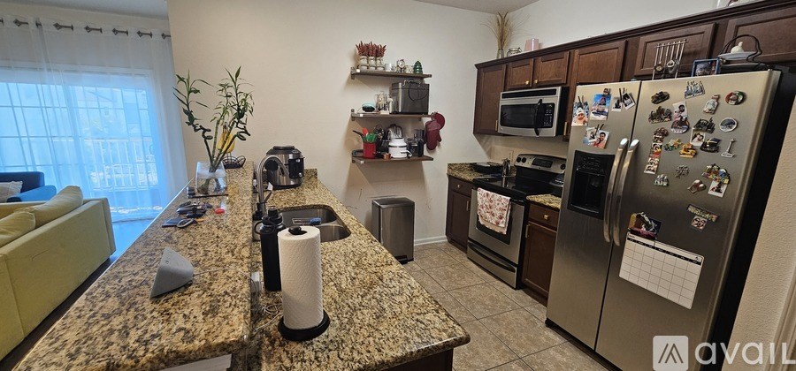 A kitchen with granite countertops and a fridge with many magnets.