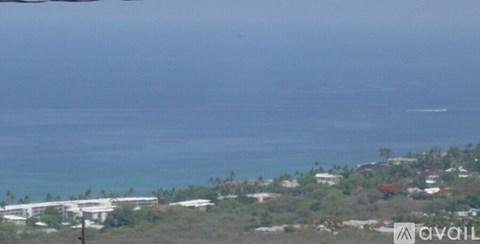 A view of a coastal area with buildings and greenery.
