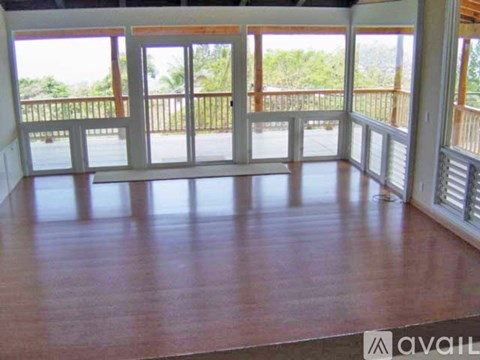 A room with a wooden floor and a balcony with a railing.