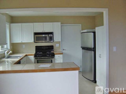 A kitchen with white cabinets and appliances.