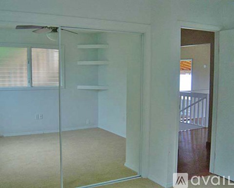 A room with a sliding glass door and a fan on the ceiling.
