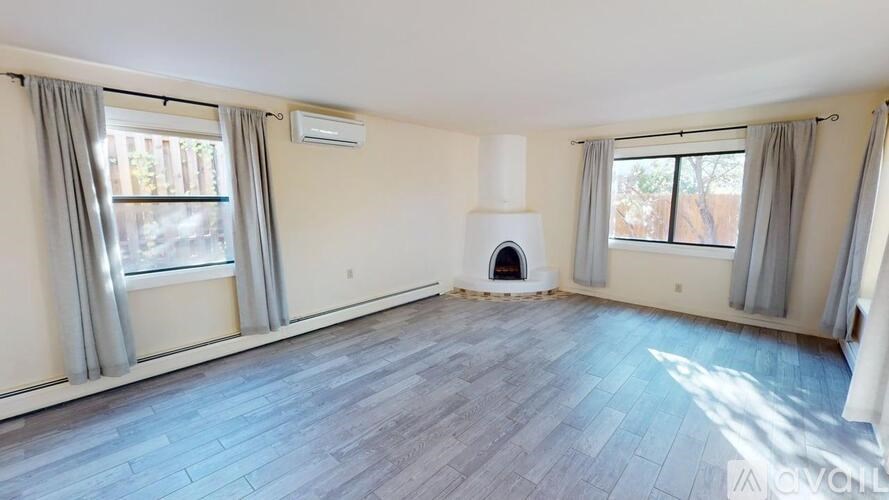 A spacious room with a fireplace and large windows.