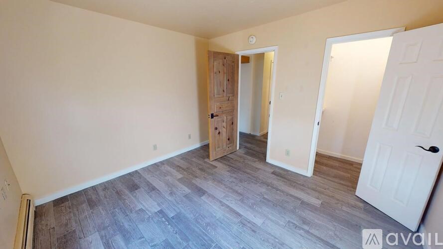 A room with a white door and a wooden door in the middle.